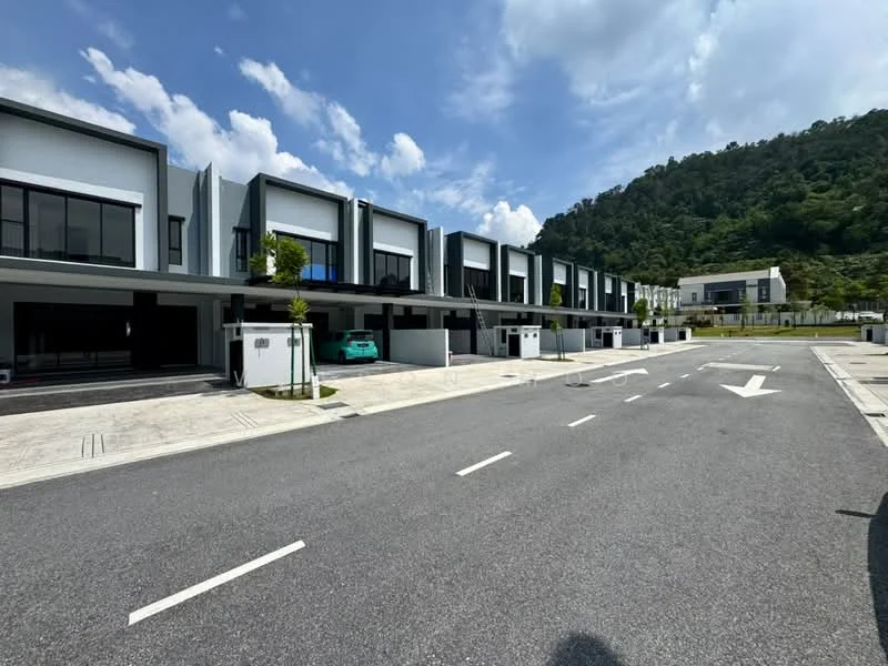 Exterior type: linked terrace house; features: modern facade with grey and white elements, two-storey structure, large windows on each unit, driveway with interlocking pavers, manicured landscaping with small trees, car porch for each unit, surrounded by greenery, clear blue sky, mountain backdrop, well-maintained road, visible parking spaces; style: modern.