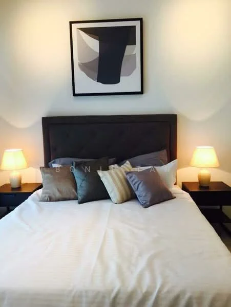 Bedroom features: king-size bed, upholstered headboard, decorative throw pillows in various colors, bedside lamps with warm light, white bed linens, framed artwork on the wall, nightstands on either side of the bed; style: modern.