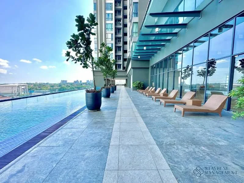 Exterior type: high-rise condominium; features: infinity pool, pool deck with loungers, glass curtain wall, stone-paved walkway, planters with greenery, outdoor seating area, city skyline view, modern architectural design; style: modern.