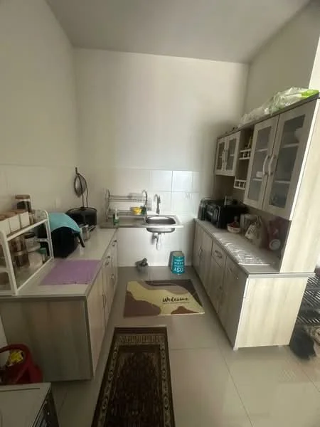 Kitchen features: light wood cabinetry, white tiled backsplash, single-bowl stainless-steel sink, chrome pull-down faucet, countertop with purple cutting board, built-in microwave, coffee machine, toaster, kitchen rug with welcome text, ceramic tile flooring, open shelving, glass-front upper cabinets, appliances on countertop; style: modern.