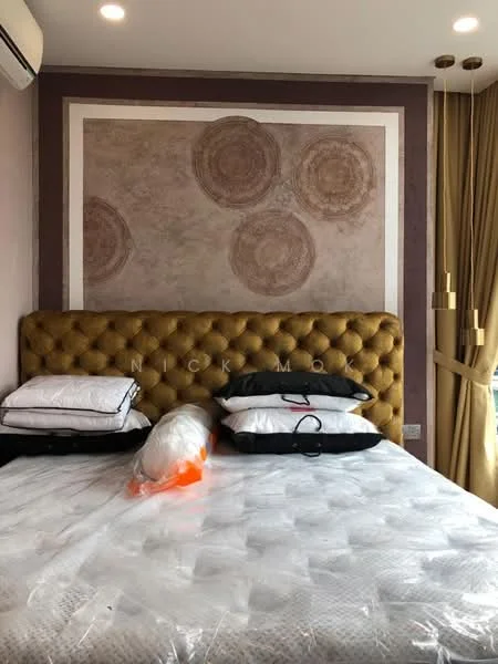 Bedroom features: king-size bed with upholstered headboard in gold, decorative wall with circular patterns, cream painted walls, floor-to-ceiling windows with sheer curtains, 2 pendant lights hanging from the ceiling, air conditioning unit on the wall, mattress with protective cover, multiple pillows on the bed; style: modern.