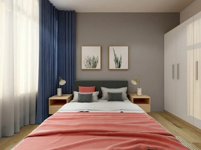 Bedroom features: queen-size bed with grey upholstered headboard, white bedding with decorative pillows in grey and coral, two bedside tables with lamps, framed artwork on walls, built-in wardrobe with sliding doors, floor-to-ceiling windows with sheer curtains, dark blue curtains, wooden flooring; style: modern.