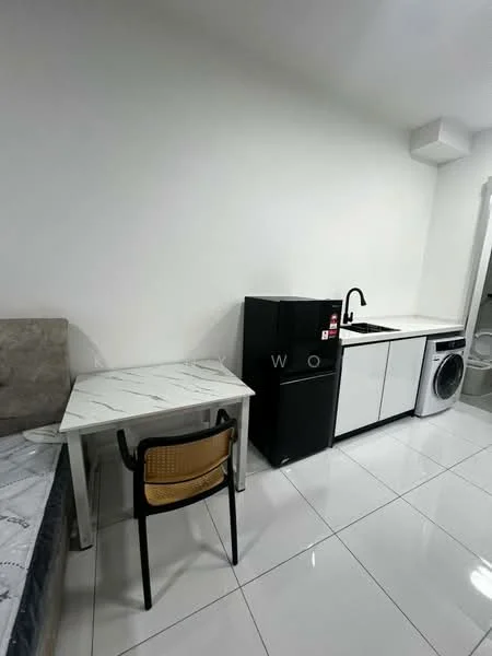 Room features: white painted walls, glossy white tile flooring, marble-patterned table, black refrigerator, white kitchen cabinets, stainless-steel sink, built-in washing machine, single chair with woven seat, bed with grey upholstered headboard; style: modern.