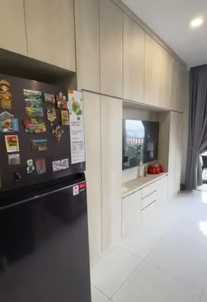 Kitchen features: black fridge, light wood cabinetry, white countertop, built-in TV unit, wall-mounted storage, white tile flooring, grey curtains, decorative items on shelves; style: modern.