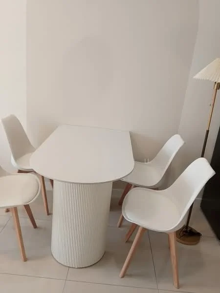 Dining features: white dining table with ribbed base, 4 white dining chairs with wooden legs, lampshade floor lamp, light-colored tiled flooring, plain white walls; style: modern.