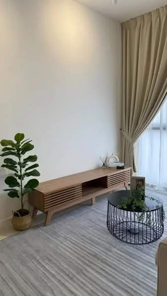 Living features: light grey area rug, wooden TV console with slatted design, black wire coffee table, green potted plant, floor-to-ceiling window with sheer curtains, cream painted walls, beige curtains, decorative items on console; style: modern.