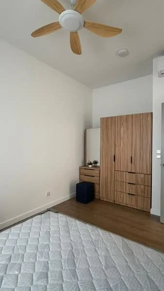 Bedroom features: wooden flooring, white painted walls, 5-blade ceiling fan, built-in wardrobe with wood finish, dresser with mirror, single bed mattress, nightstand, natural light from window; style: modern.