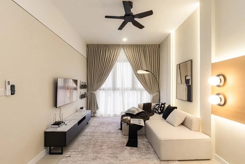 Living features: 5-blade ceiling fan in black, wall-mounted TV, white media console, light grey sectional sofa, black and white decorative pillows, floor lamp with curved arm, area rug with neutral tones, curtains in light beige, large windows with sheer curtains, wall-mounted light fixtures, decorative wall art, neutral painted walls; style: modern.