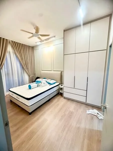 Bedroom features: queen-size bed, upholstered headboard, white bedding with blue accents, wooden flooring, built-in wardrobe with white finish, ceiling fan, floor-to-ceiling windows with sheer curtains, decorative wall paneling, nightstand, light fixture, folded bedding on the floor; style: modern.