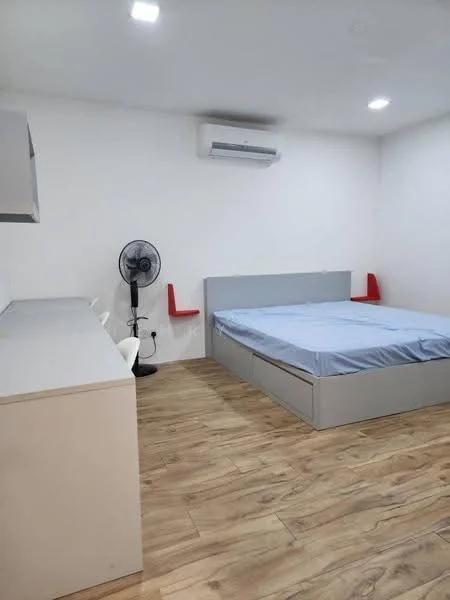 Bedroom features: queen-size bed with grey frame, light blue bed linen, wooden flooring, white painted walls, 1 wall-mounted split AC, desk with storage drawers, 2 white chairs, standing fan, red accent chairs mounted on wall, recessed ceiling lights; style: modern.