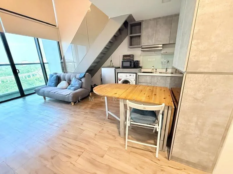 Living features: grey fabric sofa, wooden dining table, white dining chair, kitchenette with grey cabinetry, stainless-steel sink, built-in oven, washing machine, refrigerator, wood-look laminate flooring, large glass sliding door, window with sheer curtains, staircase with metal railing; style: modern; view: garden.