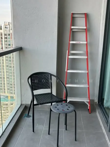 Balcony features: grey tiled flooring, glass railing, black perforated chair, metal stool, red ladder, concrete wall, city view; style: modern; view: city.