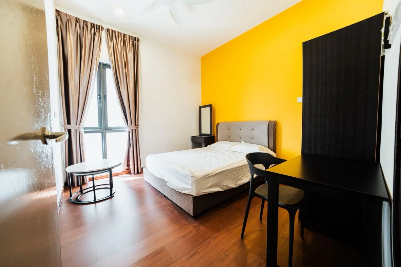 Bedroom features: queen-size bed with upholstered headboard, black study desk, black chair, round coffee table, floor-to-ceiling window, sheer curtains, orange accent wall, light wood flooring, mirror on dresser, wall-mounted light fixture, built-in wardrobe; style: modern.