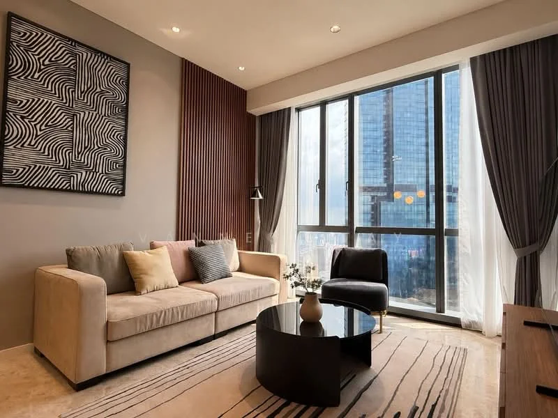 Living features: 3-seater fabric sofa in beige, decorative cushions in various colors, black round coffee table, area rug with geometric pattern, floor-to-ceiling windows, curtains in light grey, wood paneling on one wall, framed abstract artwork on wall, recessed ceiling lights; style: modern; view: city.