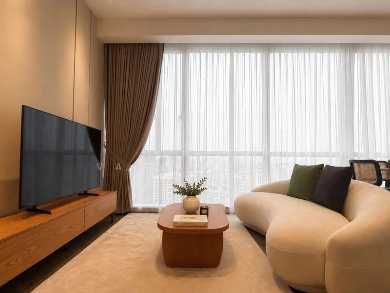 Living features: floor-to-ceiling windows, sheer curtains, light beige walls, cream area rug, curved white sofa, wooden coffee table, TV console in wood, wall-mounted flat-screen TV, decorative plant on table, green and black accent cushions, modern armchair, recessed lighting; style: modern; view: city.