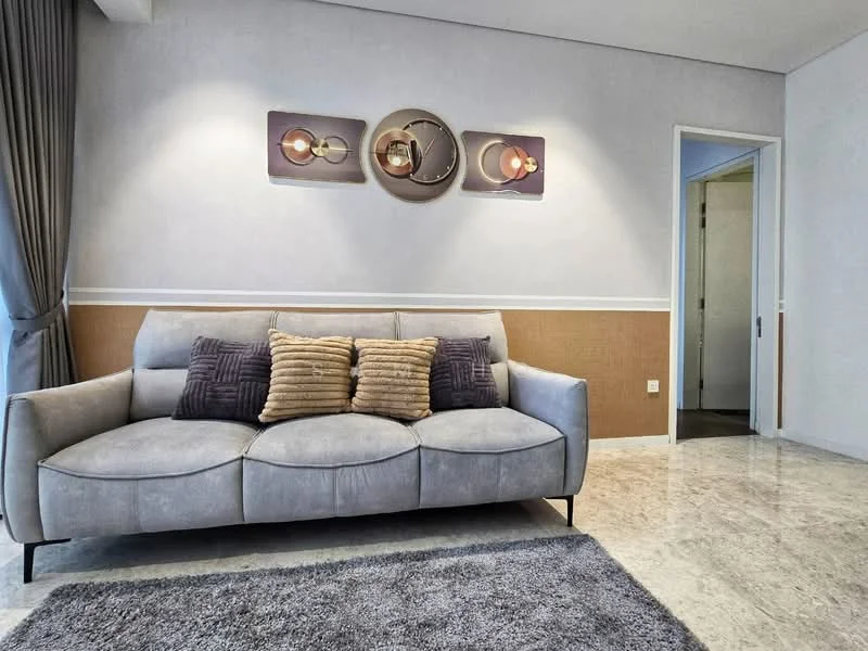 Living features: grey fabric sofa with cushions, decorative wall art, cream painted walls, brown accent wall, marble flooring, area rug, curtains, doorway to another room; style: modern.