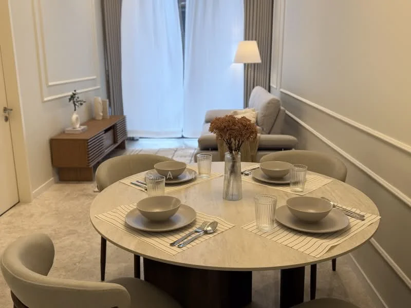 Dining features: round dining table with marble top, 4 upholstered dining chairs, table setting with plates and glasses, decorative vase with dried flowers, light-colored walls, neutral-toned flooring, sideboard with wooden finish, floor lamp, sheer curtains, natural light from window; style: modern. Living features: 2-seater fabric sofa in light grey, wooden sideboard, decorative items on sideboard, light-colored walls, neutral-toned flooring; style: modern.