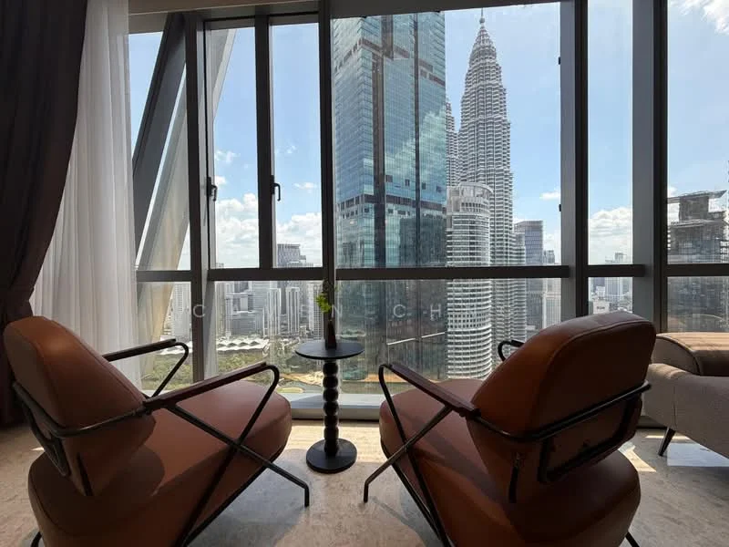 Room features: floor-to-ceiling windows, city skyline view, two brown leather armchairs, small round side table, marble flooring, curtains, natural light; style: modern; view: city.