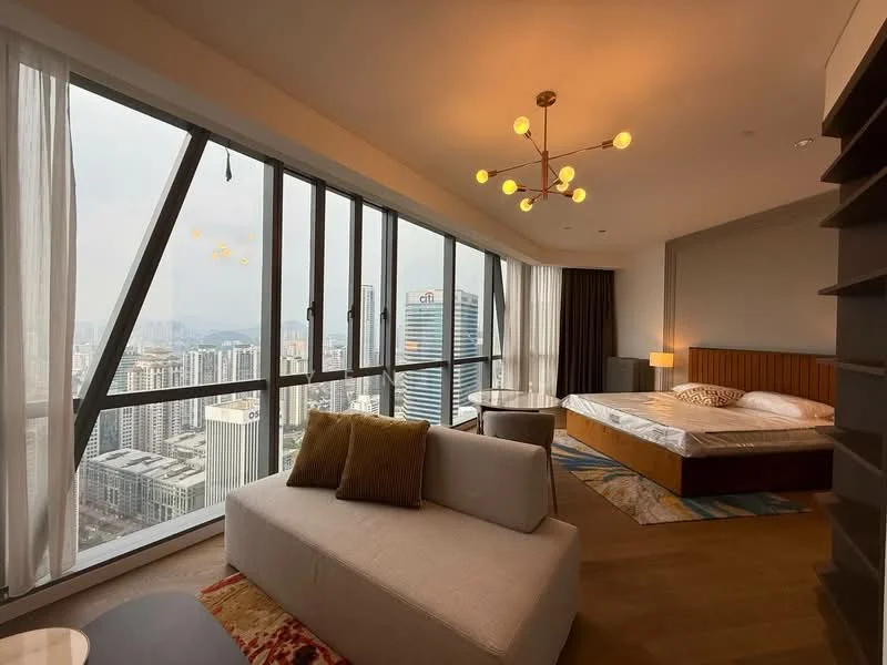 Bedroom features: king-size bed, upholstered headboard, floor-to-ceiling windows, city skyline view, wooden flooring, chandelier with multiple bulbs, side table with lamp, sofa in light fabric, decorative cushions, area rug with geometric pattern; style: modern; view: city.