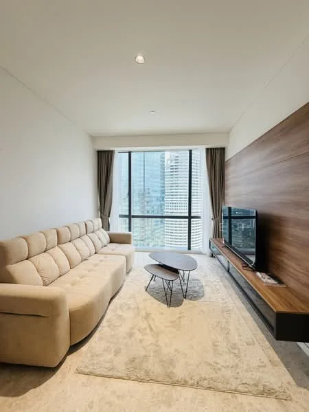 Living features: beige fabric 3-seater sofa, round coffee table, TV console, wall-mounted TV, area rug, floor-to-ceiling windows, curtains, wood accent wall, recessed downlights; style: modern; view: city.