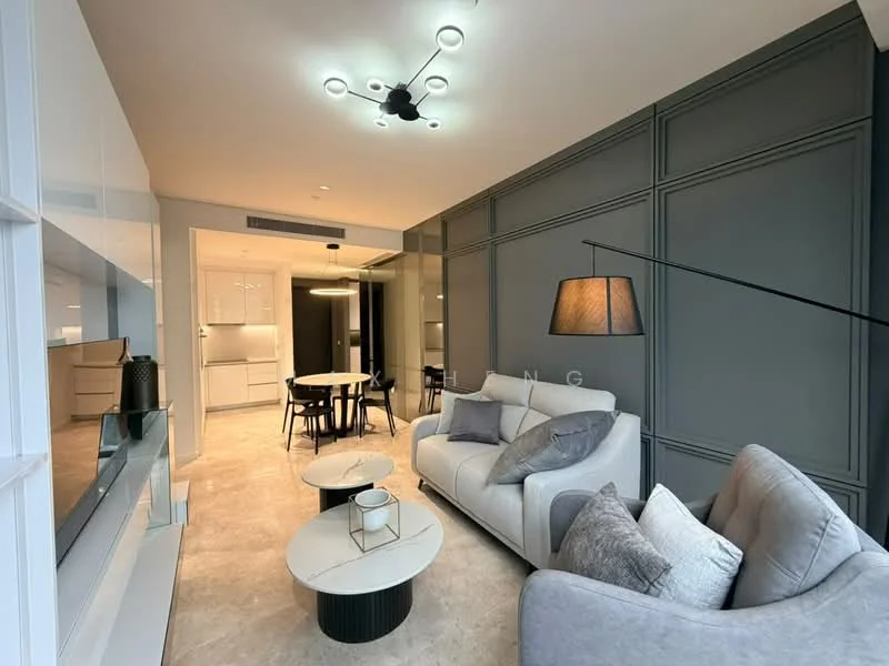 Living features: 3-seater fabric sofa in light grey, 2-seater fabric sofa in light grey, coffee table with round white top and black base, side table with black base, pendant light fixture with multiple bulbs, wall-mounted TV unit with white cabinetry, grey accent wall with paneling, marble tile flooring, decorative cushions in various shades, floor lamp with black shade; style: modern. Dining features: round dining table, 4 upholstered dining chairs in black, white cabinetry in background, open-plan layout connecting to kitchen, marble tile flooring; style: modern.
