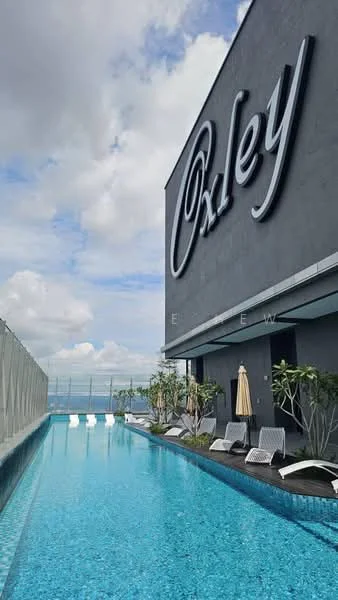 Exterior type: high-rise condominium; features: infinity pool, pool deck with loungers, landscaped area with plants, glass railing, modern facade, outdoor umbrellas, water feature, skyline view, sunny weather, blue tiled pool; style: modern.