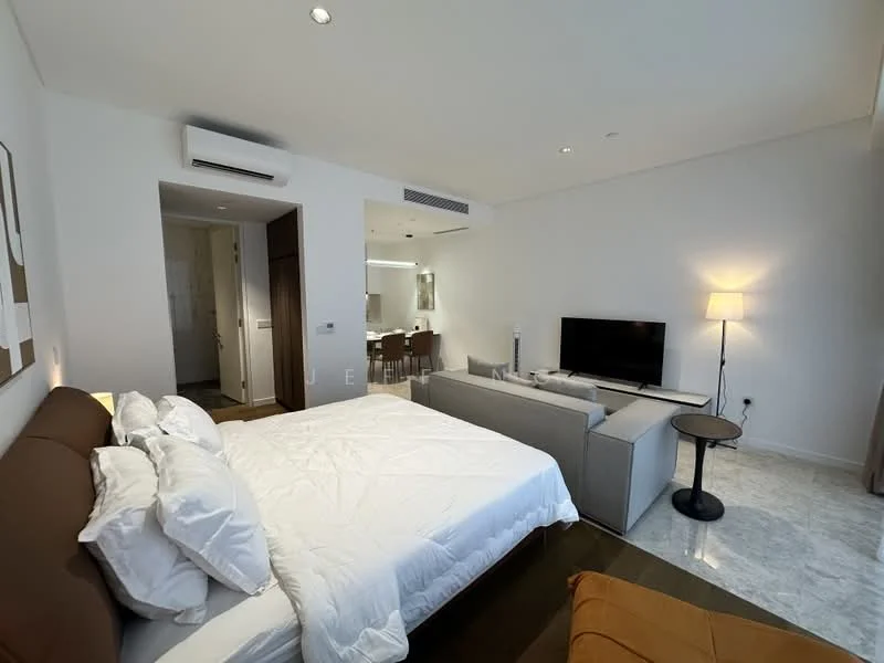 Bedroom features: king-size bed with white bedding, upholstered headboard, sofa in grey fabric, coffee table, wall-mounted TV, floor lamp, marble flooring, air conditioning unit, decorative artwork on wall, window with natural light, built-in wardrobe, dining table with chairs in background, neutral painted walls; style: modern.