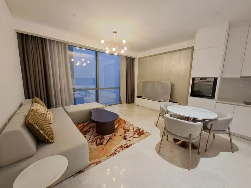 Living features: light grey fabric sofa, round coffee table with dark base, area rug with geometric pattern, white dining table, 4 upholstered dining chairs, wall-mounted TV, built-in cabinetry, floor-to-ceiling windows, sheer curtains, chandelier with multiple bulbs, marble flooring, accent wall with textured finish; style: modern; view: sea.