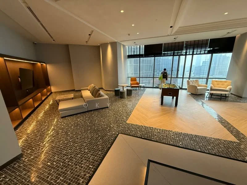 Living features: large floor-to-ceiling windows, city skyline view, grey tiled flooring, light wood herringbone flooring, modern sectional sofa in light grey, white armchair, coffee table with glass top, pool table, built-in wall unit with lighting, decorative wall paneling, recessed ceiling lights, area rug with geometric pattern; style: modern; view: city.
