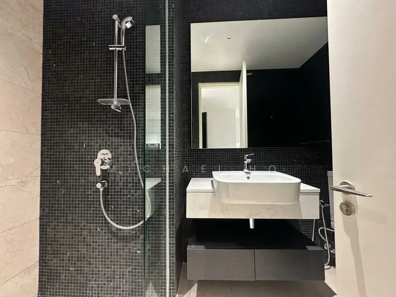 Bathroom features: black mosaic tile walls, light marble flooring, walk-in shower with glass enclosure, rain shower head, handheld shower, floating vanity with white basin, mirror above vanity, chrome faucet, built-in storage underneath vanity, recessed lighting; style: modern.
