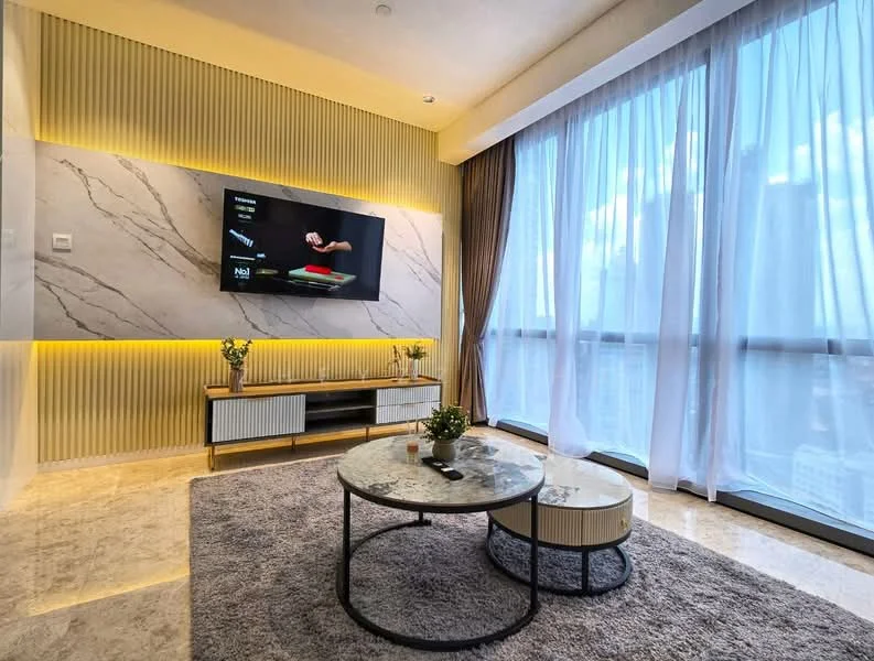 Living features: marble feature wall, wall-mounted TV, light wood media console, round coffee table with black metal frame, beige area rug, floor-to-ceiling windows, sheer curtains, dark brown curtains, recessed LED lighting, decorative plants; style: modern; view: city.