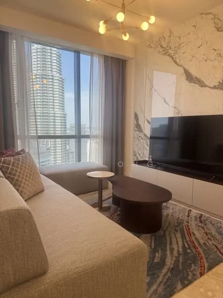 Living features: beige fabric sofa, round coffee table, TV console with flat-screen TV, marble accent wall, area rug with abstract pattern, floor-to-ceiling windows, sheer curtains, chandelier with multiple bulbs; style: modern; view: city.