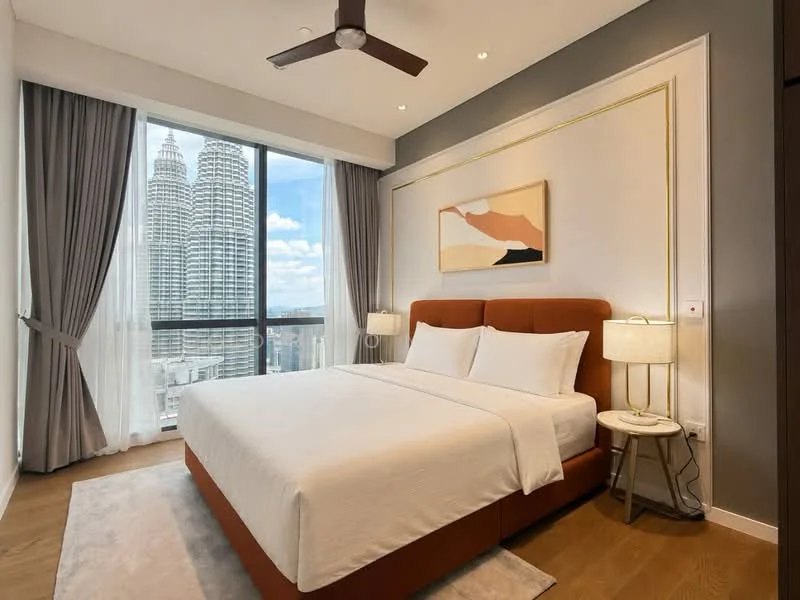 Bedroom features: king-size bed with upholstered headboard, two bedside tables, table lamps, floor-to-ceiling windows, curtains, wooden flooring, decorative wall art, accent wall with gold trim, ceiling fan with light, city view of Petronas Twin Towers; style: modern; view: city.