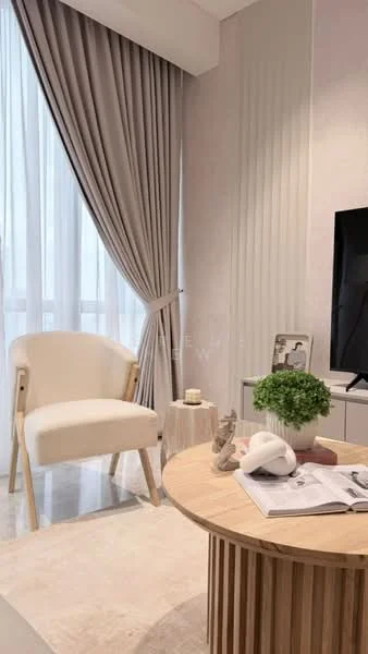 Living features: light grey walls, floor-to-ceiling windows, sheer curtains, cream upholstered armchair, round wooden coffee table, decorative plant on table, magazine on coffee table, decorative sculpture on table, area rug, wall-mounted TV, textured wall paneling; style: modern; view: city.