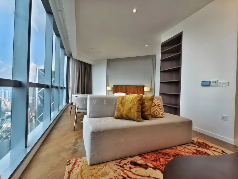 Living features: floor-to-ceiling windows, grey fabric sofa, two yellow decorative cushions, area rug with abstract pattern, wooden flooring, built-in shelving unit, wall-mounted control panel, recessed downlights; style: modern; view: city.