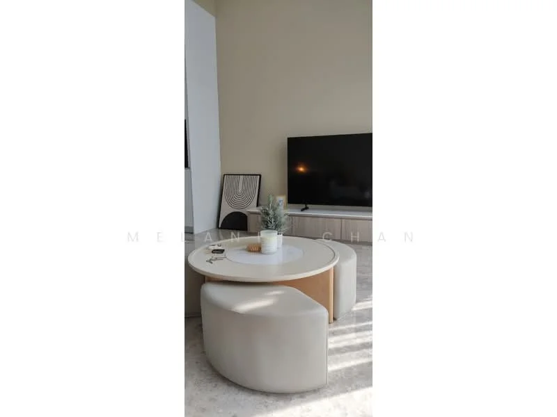 Dining features: round dining table, white tabletop, light wood base, 2 upholstered chairs in cream, decorative plant in pot, framed artwork on wall, wall-mounted TV, light-colored cabinetry, neutral wall color, natural light from window; style: modern.