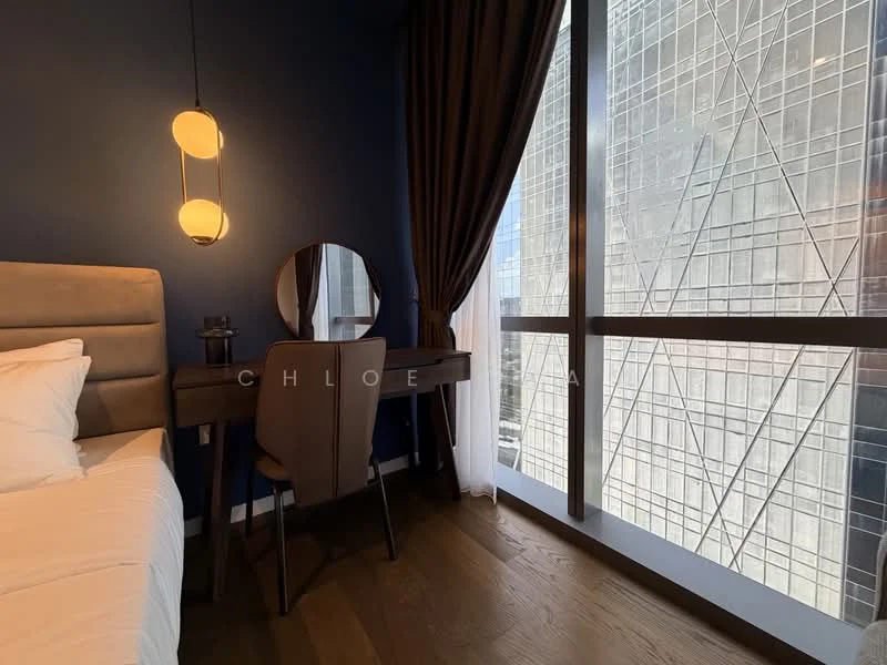 Bedroom features: blue accent wall, grey upholstered bed, white bedding, wooden flooring, desk with chair, round mirror, floor-to-ceiling windows, sheer curtains, city skyline view, pendant light fixture; style: modern; view: city.