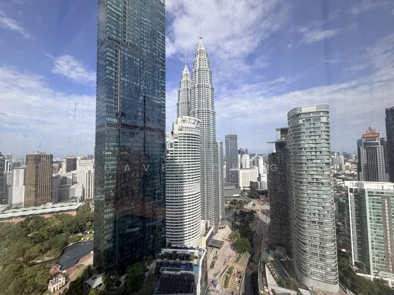 Exterior type: high-rise condominium; features: glass curtain wall, surrounded by city skyline, view of Petronas Twin Towers, modern architectural design, multiple high-rise buildings, urban landscape, green park area visible; style: modern.