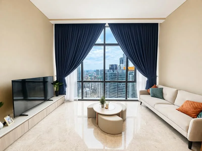 Living features: floor-to-ceiling windows, blue curtains, cream painted walls, marble flooring, 3-seater fabric sofa in beige, decorative cushions in orange, coffee table with round design, TV console, wall-mounted TV, houseplant in ceramic pot, framed photo on console; style: modern; view: city.