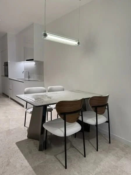 Dining features: marble dining table, 4 white upholstered dining chairs, pendant light fixture, white painted walls, tile flooring, open kitchen area visible in background, stainless-steel sink, built-in cabinetry; style: modern.