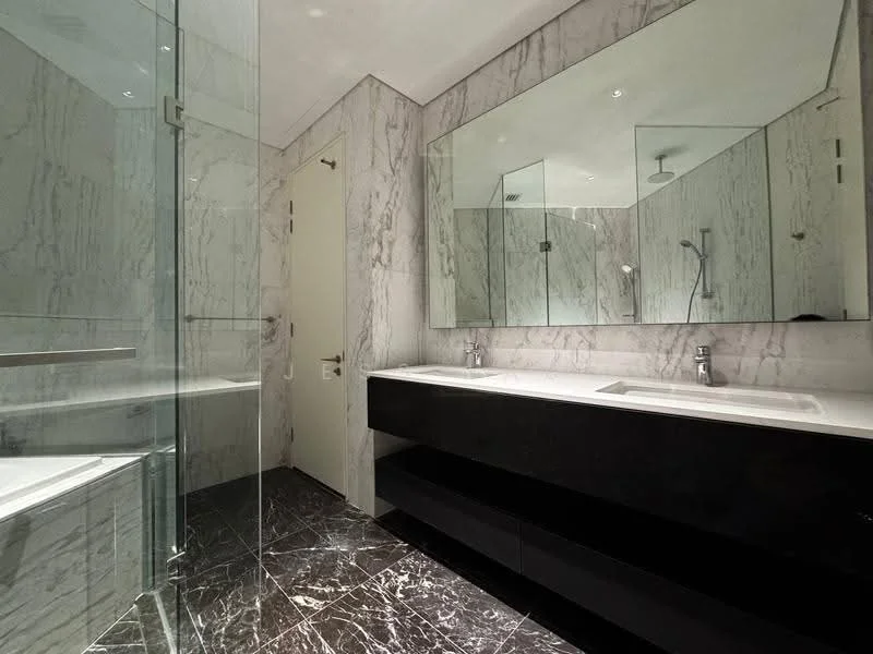Bathroom features: double-sink vanity with black cabinetry, white stone countertop, two chrome basin mixers, large wall-mounted mirror, glass shower enclosure, rain shower head, bathtub, marble wall cladding, black marble flooring, recessed downlights, white painted ceiling; style: modern.