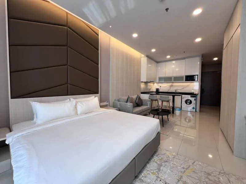 Room features: queen-size bed with upholstered headboard, white bedding, light grey accent wall, wood paneling, white painted walls, recessed downlights, floor-to-ceiling windows, kitchenette with white cabinetry, built-in microwave, stainless-steel fridge, washing machine, grey sofa, round dining table with two chairs, marble flooring; style: modern.