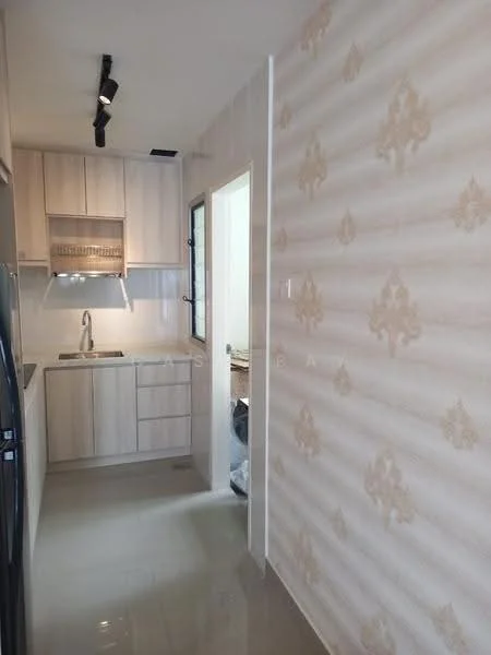 Kitchen features: light wood cabinetry, single-bowl stainless-steel sink, chrome pull-down faucet, white tiled backsplash, black refrigerator, countertop with light surface, wall-mounted cabinets, recessed lighting, cream wallpaper with floral pattern, grey floor tiles; style: modern.