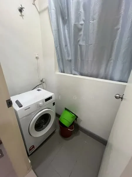 Laundry features: front-load washing machine, grey tiled flooring, white painted walls, window with grey curtain, green plastic bucket, red plastic bucket.