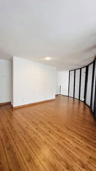 Room features: laminate flooring, white painted walls, recessed downlights, large windows with horizontal slats, open layout, smooth ceiling, wood trim, natural light; style: modern.