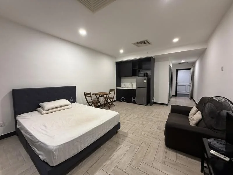 Room features: queen-size bed with upholstered headboard, white bedding, wooden dining table for two, two wooden chairs, black fabric sofa, floor-to-ceiling windows, light-colored tile flooring, white painted walls, kitchenette with built-in cabinets, refrigerator, microwave, sink, stove, air conditioning unit; style: modern.
