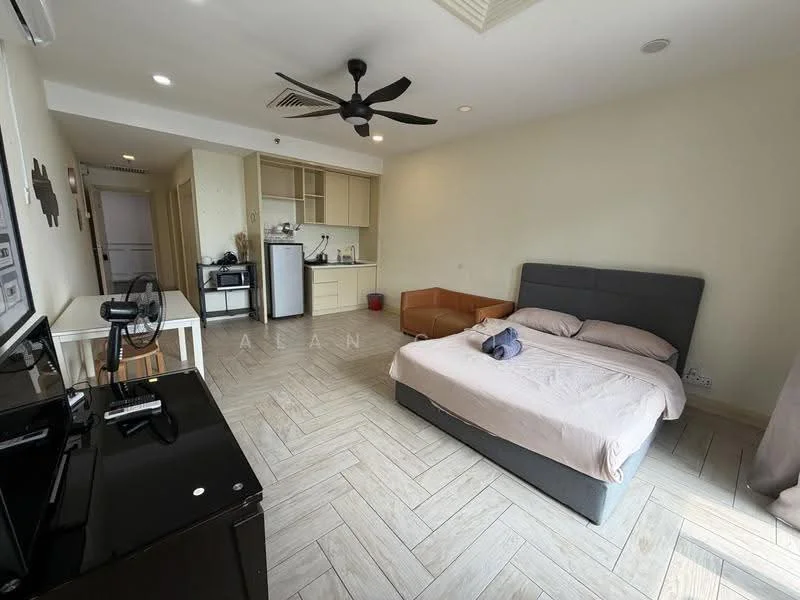 Living features: queen-size bed with grey upholstered headboard, beige bedding, 2-seater orange sofa, black TV console, wall-mounted TV, ceiling fan with light, wooden flooring with herringbone pattern, small dining table with 2 chairs, refrigerator, kitchenette with cabinets, sink, microwave, kettle; style: modern.