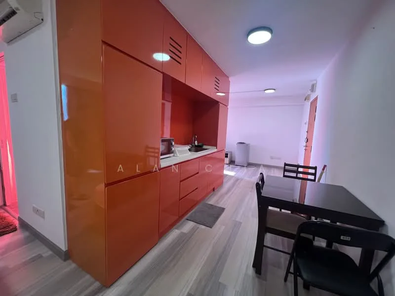 Kitchen features: orange high-gloss cabinetry, white countertop, single-bowl stainless-steel sink, chrome pull-down faucet, built-in microwave, stainless-steel kettle, black dining table, black dining chairs, grey floor mat, recessed LED downlights, laminate flooring, white walls; style: modern.