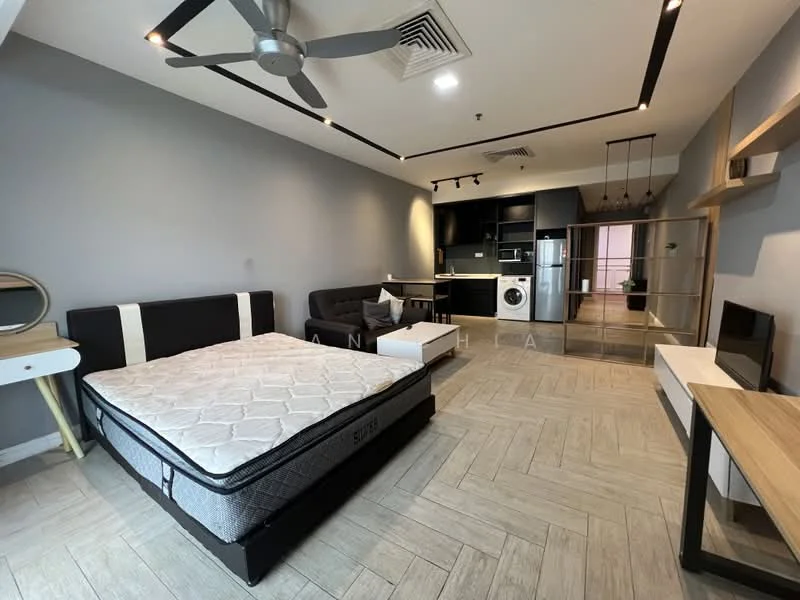 Living features: grey painted walls, wood-look tile flooring, 5-blade ceiling fan with light, sofa bed in black, queen-size mattress on bed frame, wall-mounted TV, TV console in white, open shelving unit, kitchen area with black cabinetry, stainless-steel washing machine, refrigerator, kitchen countertop with bar seating, pendant lighting above kitchen area; style: modern.
