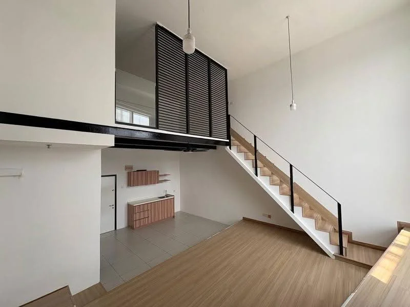Living features: high ceiling, large windows, wooden flooring, white painted walls, open layout, staircase with wooden steps, black metal railing, pendant lighting, kitchenette with cabinetry, tile flooring in kitchenette, shelving unit; style: modern.